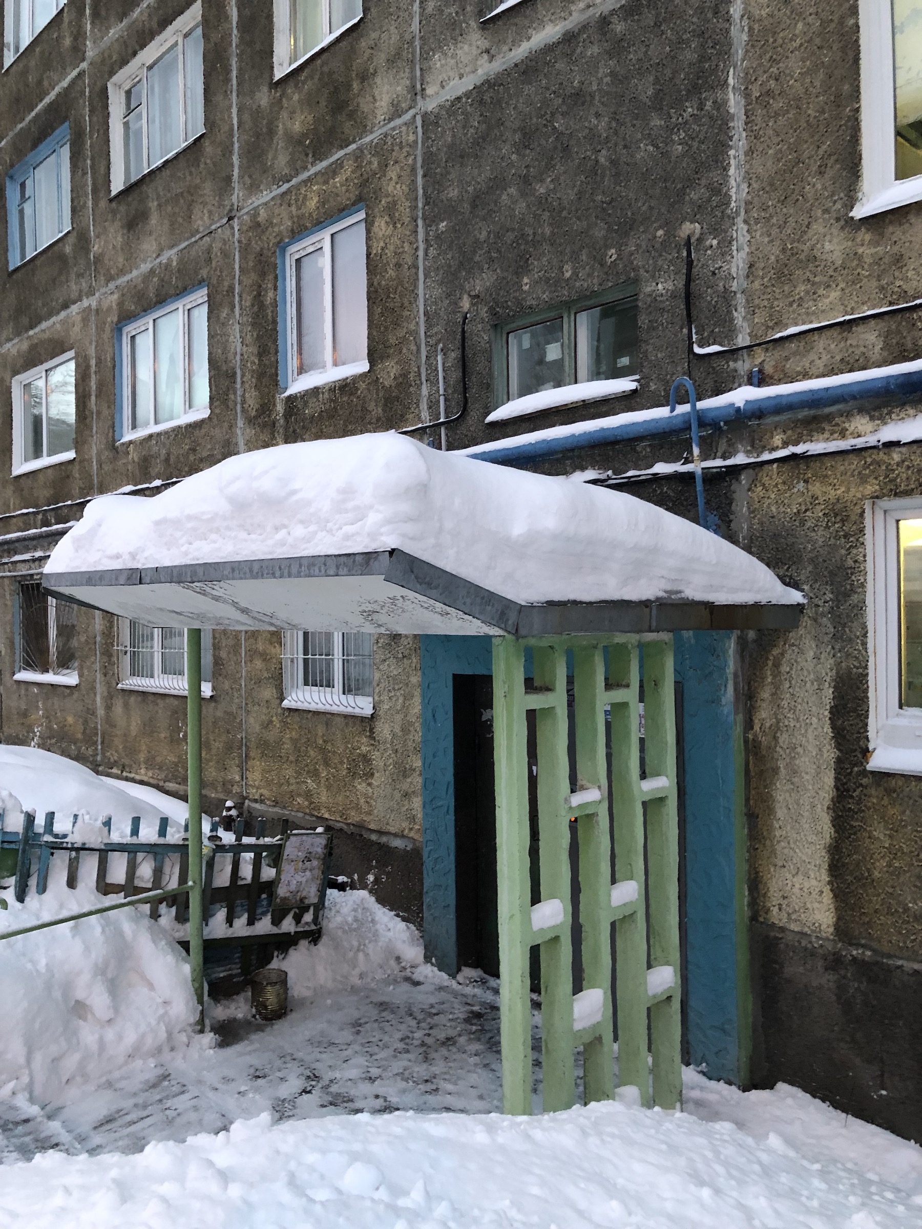 Заснеженный козырек подъезда в Мурманске